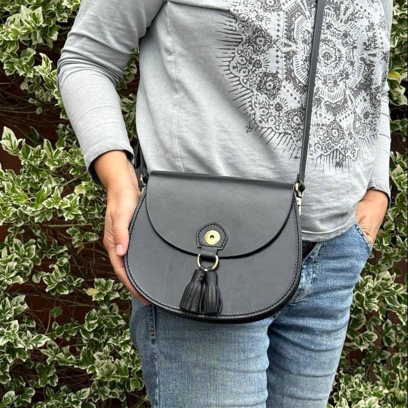 1. Black vegetable‑tanned leather satchel on chair