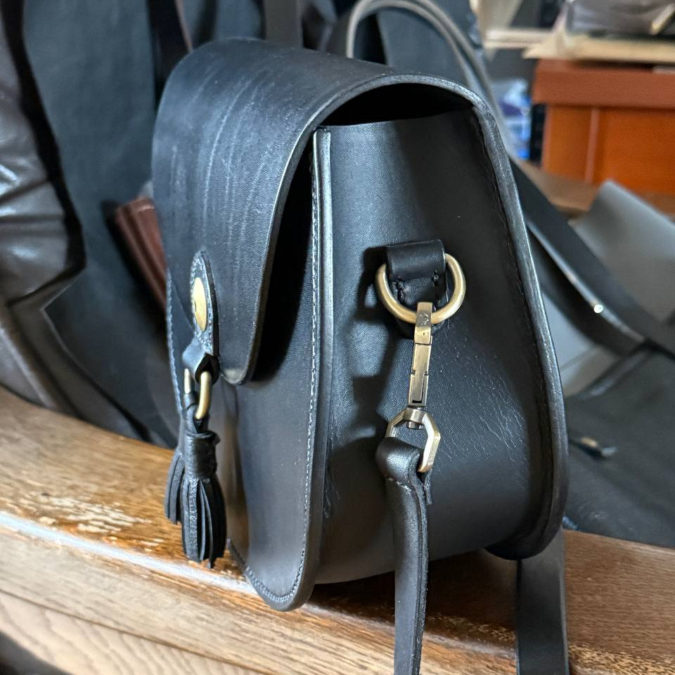 Black leather crossbody bag flat lay