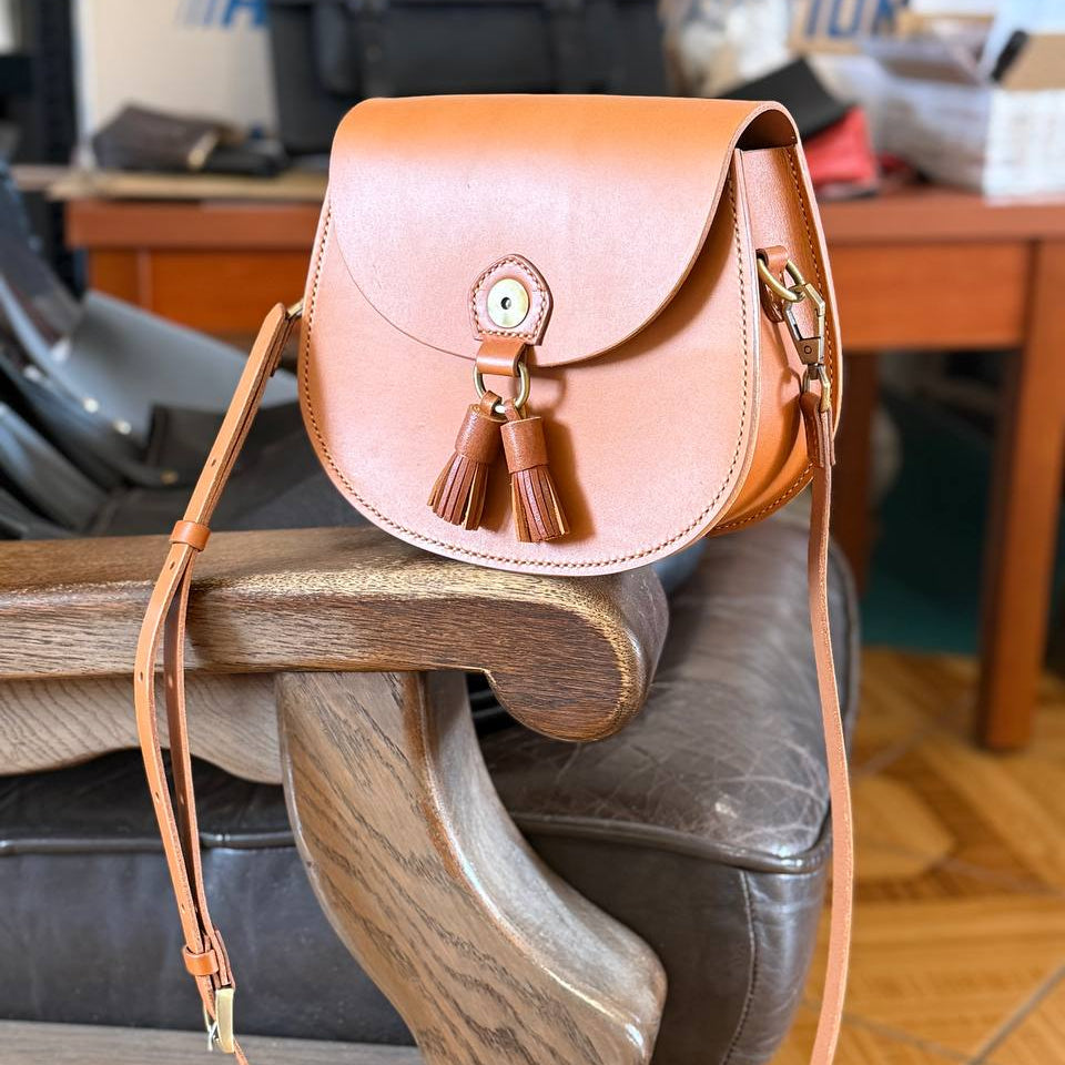 Tan leather satchel with saddle stitching close‑up 